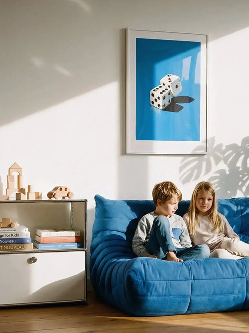 Framed dice art print on wall above blue sofa with two children in bright living room